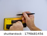 Digital detector man hand is scanning wall by sensors precision stud finder wooden beams soft focus