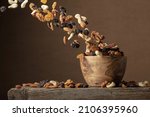 Small photo of Flying dried fruits and nuts. The mix of nuts and raisins in a wooden bowl. Copy space.