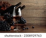 Red wine and blue grapes. Wine and grapes in a vintage setting on an old wooden table.