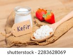 Small photo of Kefir grains in wooden spoon in front of cups of Kefir Yogurt Parfaits. Kefir is one of the best health foods available providing powerful probiotics.