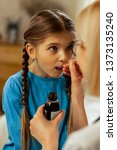 Small photo of A child taking medicine. Face portrait of a small sweet long-haired girl taking vapid cough syrup given by a pediatrician