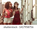 Small photo of Amazed sensuous beauties. Beautiful alluring long-haired prepossessing tanned amazed sensuous beauties enjoying strolling the streets.