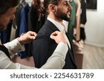 Small photo of Experienced clothier altering suit of male client