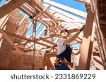 Small photo of Confident forewoman standing at ladder and evaluating building stage