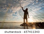 A Fisherman Cast A Net At Lake...