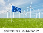 Official flag of the European Union on grass in front of a large windpark with wind turbines