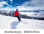 Young happy man skiing in Kitzbuehel ski resort and enjouing the beautiful weather with blue sky and Alpine mountains in Austria. 