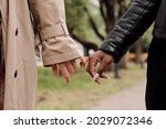 Small photo of Hands of amorous intercultural girlfriends taking walk in park at leisure