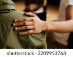 Small photo of Hand of young supportive man consoling his friend or one of attendants with post traumatic syndrome caused by dramatic life event