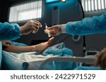 Small photo of Gloved hand of surgeon taking syringe with local anaesthesia during surgical operation against leg of patient lying on operating table