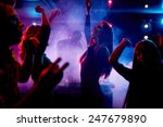 Group of dancing young people enjoying night in club
