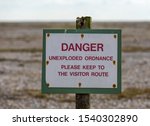 Small photo of Sign to keep you to the path. " Danger unexploded ordnance, please keep to the visitor route"