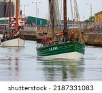 Small photo of Lowestoft, Suffolk, UK. July 30 2022. International historic smack and drifter race. Swan LK243, built 1900 in Lerwick. Heading through the inner harbour on the river Waveney out to the north sea.