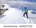 Woman climbing on touring skis in sunny winter day, Les Deux Alpes, France