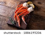 Delicious snow crab leg clusters on a rustic wood table top.