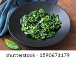 vegetarian food cooked spinach in black dish 