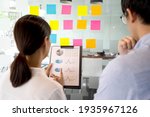 Small photo of Businessman with staff stand to consult information data and prepare to jot down the information on color paper stuck on the wall for brainstorm