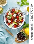 Small photo of Greek salad. Vegetable salad with feta cheese, tomato, olives, cucumber, red onion and olive oil. Healthy vegetarian mediterranean diet food. Top view