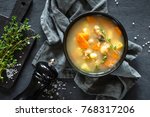 Fresh fish soup in bowl on black background, top view