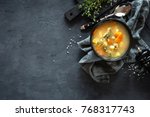 Fresh fish soup in bowl on black background, top view