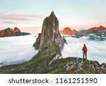 Traveler hiking on mountains ridge over clouds adventure journey traveling outdoor in Norway active vacations sunset Segla mountain