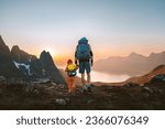 Family travel hiking adventures: father and child with backpacks in  mountains of Senja island in Norway healthy lifestyle outdoor active vacations dad with kid together   