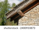 roof, particular truss with exposed wooden beams. interlocking beam structure covered with wooden beading. thermal coat, energy class, mountain hut