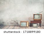 Retro cathode ray tube (CRT) monochrome television sets and classic wooden TV stand with outdated amplifier front concrete wall background. Broadcasting, news concept. Vintage old style filtered photo