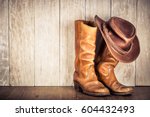 Small photo of Wild West retro leather cowboy hat and old boots. Vintage style filtered photo