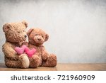 Retro Teddy Bear toys pair with handmade Valentines day love hearts front concrete wall background. Vintage instagram old style filtered photo