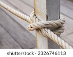 fence pole tied with rope, rope knot on fence of wooden bridge