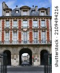 Small photo of Archway entrance to the Place des Vosges in Paris, a block of uniformly designed townhouses built in the 1600s