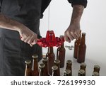 Small photo of Home brewing: a craft beer brewer closing the bottles with a bottle capper.