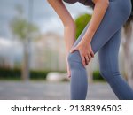 Small photo of pain and discomfort from knee injury during morning run. Young woman was running in park and suddenly felt sharp pain in knee joint due to dislocation or rupture of meniscus.