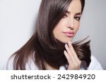 beautiful young woman holding her healthy and shiny hair, studio white