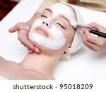 Beautiful woman with facial mask at beauty salon