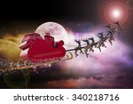 Santa Claus riding a sleigh led by reindeers following the star 