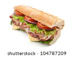 half of long tasty subway baguette sandwich with lettuce, tomatoes, ham, turkey breast, salami and cheese isolated on white background