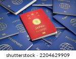 Passport of Japan on the pile of passports of other countries. Immigration, citizenship, travel and tourism concept. 3d illustration