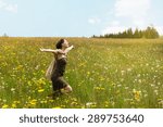 Beautiful woman running across a wildflower meadow