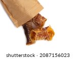 Small photo of Dog food - dried beef offal, poured out of the package (trachea) isolated on white background. Natural chewing treats.