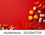 Chinese New Year 2023 festival decorations, mandarins, flowers, envelopes on red background. Flat lay, top view.