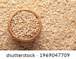 Macro Close-up of Organic White Sesame seeds(Sesamum indicum) or white Til in an earthen clay pot (kulhar) on the self background. Top view
