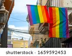 Small photo of The LGBT community flags on homes in the old city in a sign of friendly neighborliness and hospitality for all types of gender people. Somewhere on the streets of the old city in Spain, Europe.