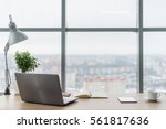 Workplace with notebook laptop Comfortable work table in office windows and city view.