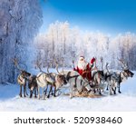 Santa Claus are near his reindeers in snowy forest.