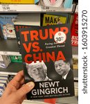 Small photo of San Jose, CA - December 28, 2019: Man holding a book by Newt Gingrich titled “Trump Vs. China”. #1 New York Times Bestselling Author.