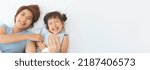 Small photo of Happy Young asian mother playing ticklish and laughing with her cute daughter on bed indoor, Selective focus at girl, Banner, Copy space