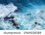 crushing sea waves texture. beautiful nature background view from above. unbelievable blue color of water. few rocks among foam
