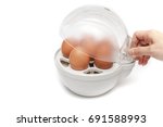 Small photo of Boiled eggs with egg boiler on white background